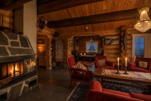 a living room with a fireplace in a log cabin at Ideal For Families 6 Bedrooms And Sauna in Beitostøl