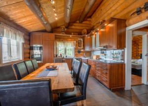 a kitchen with a wooden table and leather chairs at Ideal For Families 6 Bedrooms And Sauna in Beitostøl
