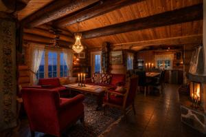 a living room with red furniture in a log cabin at Ideal For Families 6 Bedrooms And Sauna in Beitostøl