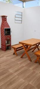 a room with a picnic table and a brick oven at Descanse perto do aeroporto e Conheça Maceió - 24h in Maceió