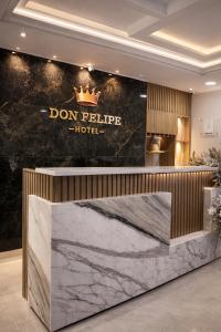 a luxury hotel lobby with a reception counter with a crown on the wall at Hotel Don Felipe in Ríohacha