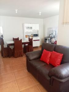 a living room with a brown couch and a kitchen at Hospedaje Kelita in Moquegua