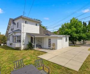 a white house with a patio and a yard at Journey House LA in Los Angeles