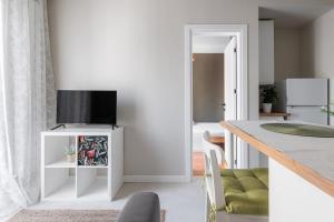 a living room with a tv on a white cabinet at Lumahaus Chamber Palaiologou in Thessaloniki