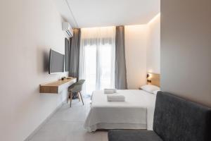 a hotel room with a bed and a desk and a window at White Tower Elegance in Thessaloniki