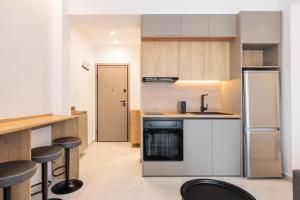 a kitchen with white cabinets and black appliances at White Tower Elegance in Thessaloniki