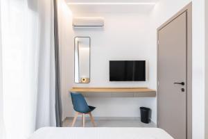 a bedroom with a blue chair and a tv at White Tower Elegance in Thessaloniki