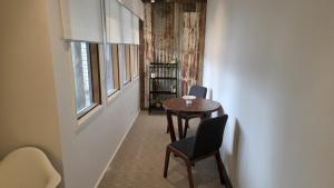 a hallway with a table and chairs and a window at Alpinwood in Dinner Plain