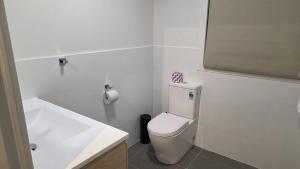 a bathroom with a white toilet and a sink at Alpinwood in Dinner Plain