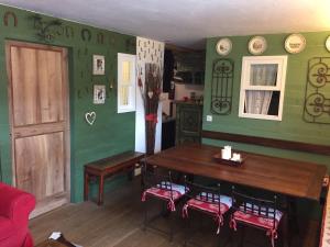 a dining room with green walls and a wooden table at meschihouse - Chesa Engadina in Samedan