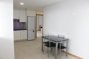 a kitchen with a table and chairs and a refrigerator at Cantinho Das Praias in Vila Franca do Campo