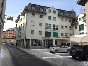 ein großes Gebäude mit davor geparkt in der Unterkunft meschihouse - Chesa Engadina in Samedan