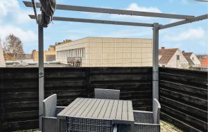 a table and chairs sitting on a rooftop patio at Amazing Apartment In Hundested With Wifi in Hundested +5 photos