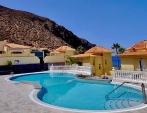 a swimming pool in front of a house at Villa Brisa Serena - Oceanfront - Los Cristianos in Los Cristianos