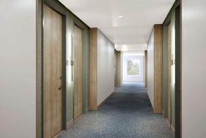 a hallway with wooden doors and a long corridor at Wyndham Garden Sartell/St. Cloud in Sartell