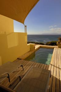 une maison avec une piscine et l'océan dans l'établissement Whalesong Lodge, à Gansbaai