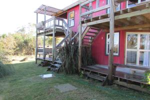 Una casa roja con escaleras al costado. en Los Monos, en La Pedrera