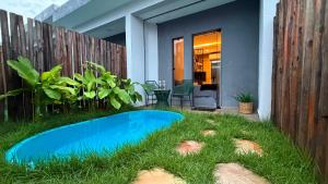 a backyard with a blue pool in the grass at Flat em Carapibus moderno e aconchegante in Conde