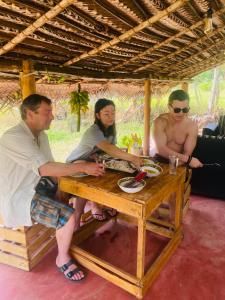 a group of three people sitting at a table at The Forest Edge Resort in Dambulla
