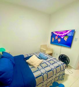 a bedroom with a bed and a tv on the wall at Apartamento em Condomínio Clube Completo com Piscina in Vitória da Conquista