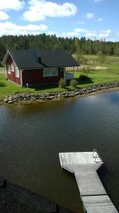 une maison sur la rive d'un lac avec un quai dans l'établissement Hannunluhdan Lomamökit, à Karijoki
