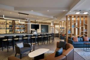 a bar in a hotel lobby with couches and chairs at Le Westin Tremblant in Mont-Tremblant
