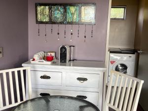 a kitchen with a table and a washing machine at Miranda Sea View Apartment in Miranda