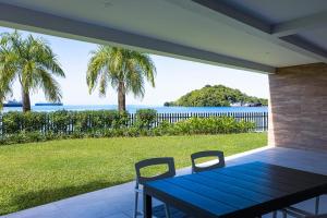 a blue table and chairs on a porch with a view of the ocean at 104 - Suva City Views Oceanfront Backyard in Suva