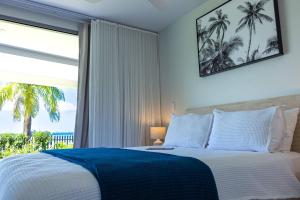 a bedroom with a bed and a large window at 104 - Suva City Views Oceanfront Backyard in Suva