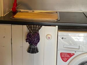 a kitchen with a washing machine and a microwave at Miranda Sea View Apartment in Miranda