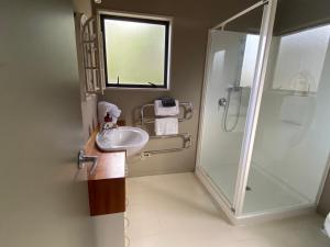 a bathroom with a sink and a shower at Miranda Sea View Apartment in Miranda