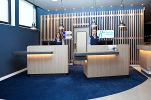 a man and a woman standing in an office lobby at Holiday Inn Express - Göppingen by IHG in Göppingen