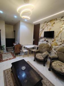 a living room with a stone wall with a table and chairs at شقة للإيجار طنطا in Tanta