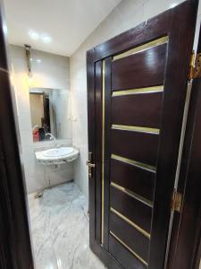 a bathroom with a wooden door and a sink at شقة للإيجار طنطا in Tanta +9 photos
