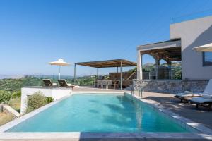 a swimming pool on the side of a house at Villa Dorothea in Georgioupoli