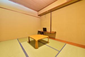 a room with a table and a bench in it at Hotel Chalet Ryuo in Yamanouchi