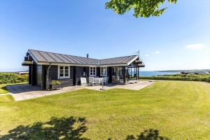 a black house with a patio and a view of the ocean at G256-Lemvig-Bellisvej-56 in Lemvig