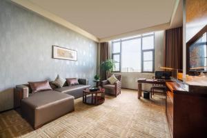 a living room with a couch and a television at Chengdu Joyhub Air Hotel in Chengdu