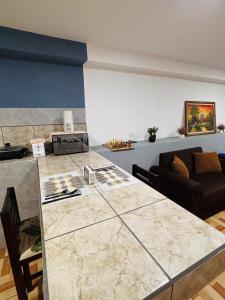 a kitchen and living room with a large marble counter top at Apartamento El Almendro in Liberia