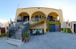 un edificio con una escalera y un patio con mesas y sillas en Alle Vigne Affittacamere, en Alcamo