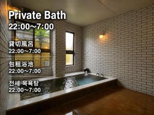 a bathroom with a bath tub in a brick wall at Kujiranoonaka in Minamitsuru