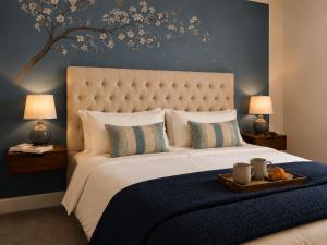 a bedroom with a large bed with a blue wall at Walk to Town, Parking, Family Home, drive to beach in Bridgend