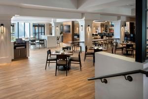a restaurant with wooden floors and tables and chairs at Boston Marriott Peabody in Peabody