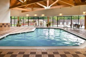 a large indoor pool with blue water in a building at Boston Marriott Peabody in Peabody