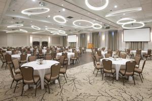 a conference room with tables and chairs and a screen at Crowne Plaza Kitchener-Waterloo by IHG in Kitchener +107 photos