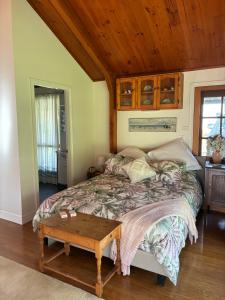 a bedroom with a bed and a wooden ceiling at Coppabella Cottage in Jingellic