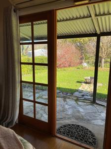 a sliding glass door with a view of a yard at Coppabella Cottage in Jingellic