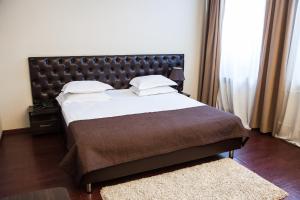 a bedroom with a large bed with a leather headboard at DK Kompleks Hotel in Novosibirsk