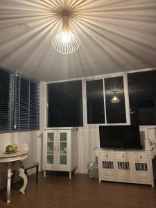 a living room with a tv and a table with a tableablish at Spectacular Sunrise and Mountain Views in Mae Nam