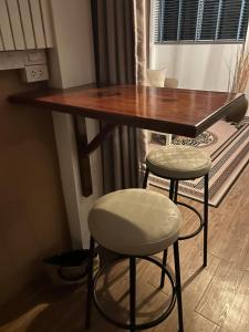 a wooden table and two stools in a room at Spectacular Sunrise and Mountain Views in Mae Nam